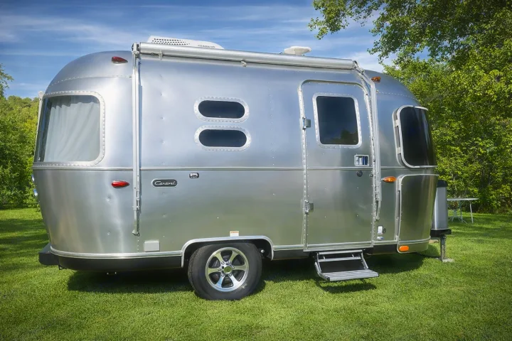 This shiny Airstream Caravel travel trailer, an ideal rv rental, is parked on vibrant green grass outdoors.. Airstream Caraval 2021
