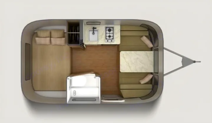 Floor plan of a compact RV rental, showing a rear bed, central kitchenette, front dinette, and small bathroom.. Airstream Caraval 2021
