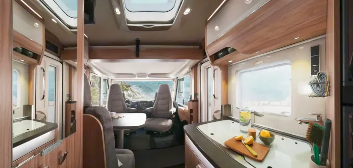 Spacious RV rental interior featuring a modern kitchen, dining area, and cockpit with mountain views for comfortable travel.. HYMER EXISIS I 474 2025