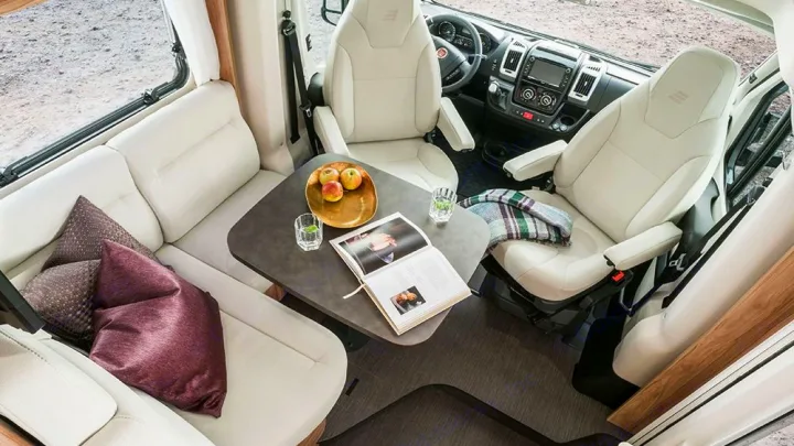 Comfortable RV rental interior, showing a bright living area, dinette, and swiveling cockpit seats.. HYMER EXISIS I 474 2025