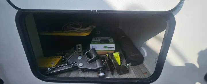 RV rental front storage with a heavy-duty hitch, electrical accessories, and leveling blocks, ready for your adventure.. Grand Design Imagine AIM 2023