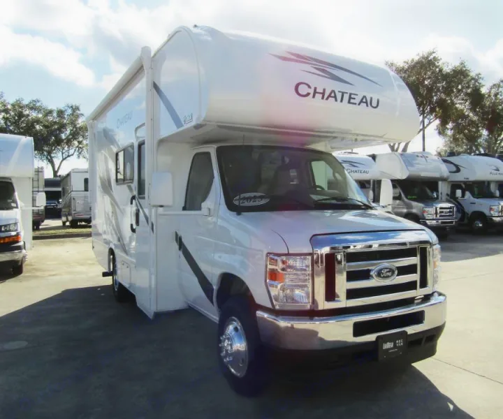 This white Chateau Class C Ford RV is ready for your next rv rental adventure, parked in a sunny lot with other motorhomes.. Thor Chateau 2025