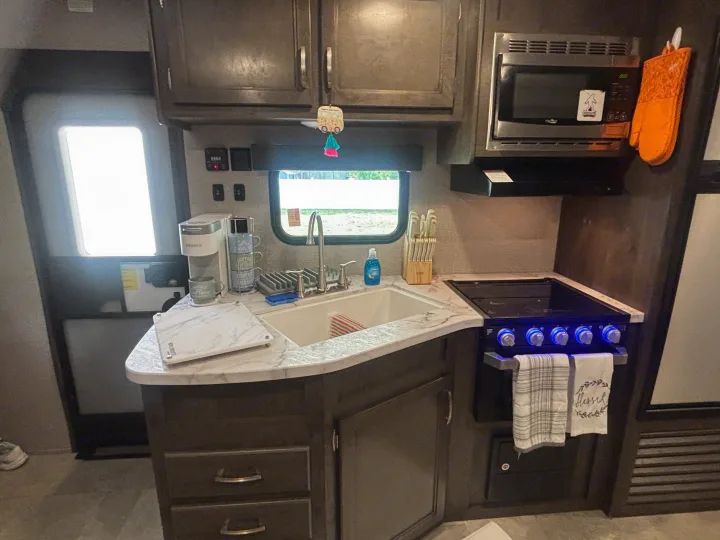 Functional RV rental kitchen: sink, stove, microwave, and coffee maker. This compact galley is ready for your adventures.. Jayco Jay Flight 2020
