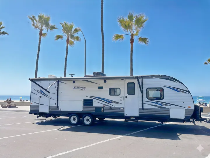 This RV rental travel trailer is parked right by a sunny beach, offering ocean views & palm trees for a perfect getaway.. Forest River Salem Cruise Lite 2019