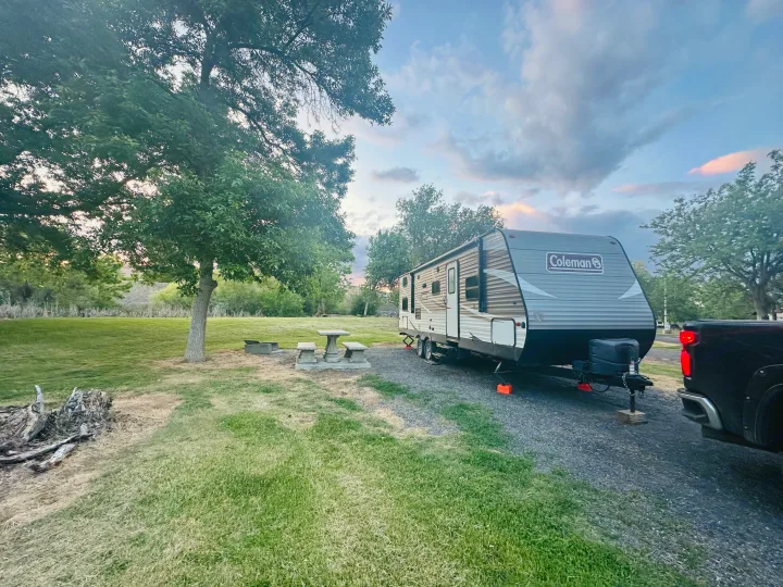 This Coleman RV rental is ready for adventure! Parked at a serene campsite with a picnic table, fire pit, and lush trees.. Dutchmen Coleman Lantern 2019