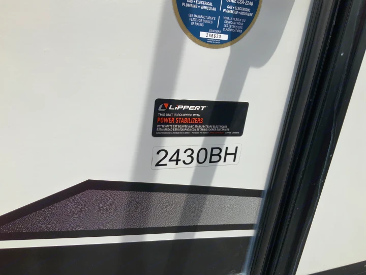 Side panel of an RV rental, featuring model 2430BH, Lippert Power Stabilizers, and CSA-Z240 rating details (issue 266633).. Keystone RV Bullet Crossfire 2022