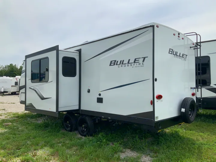 A white Keystone Bullet Crossfire travel trailer, featuring an extended slide-out, ready for your next rv rental adventure.. Keystone RV Bullet Crossfire 2022