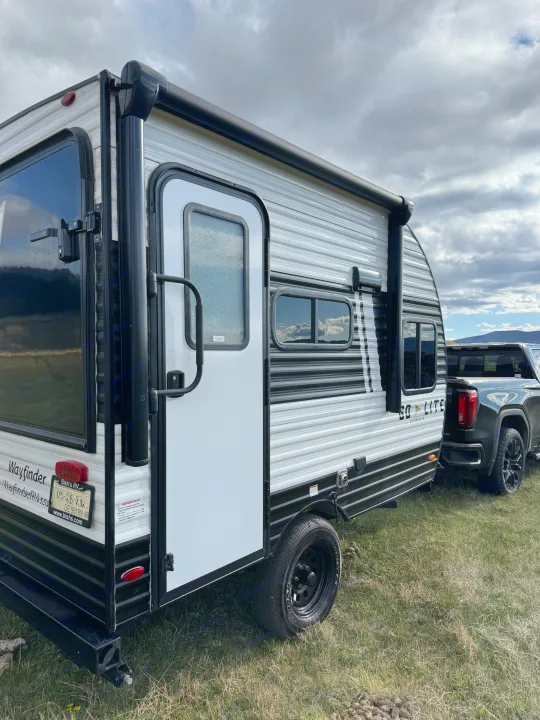 Wayfinder travel trailer RV rental, a Skybreaker model, hitched to a truck on grass, perfect for your next outdoor trip.. Wayfinder RV Go lite 2025
