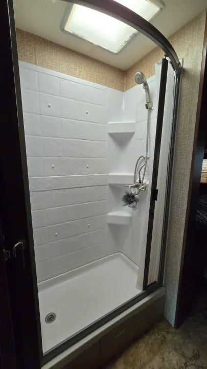 Stay fresh in this RV rental's shower, featuring a skylight, handheld showerhead, and built-in shelves for convenience.. 1F65F5DY3E0A15748 Pursuit 31 BD 2015