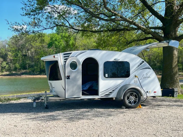 This "Luna" teardrop RV rental is perfectly parked by a tranquil lake, ready for a cozy camping adventure.. InTech RV InTech RV Trailer 2018