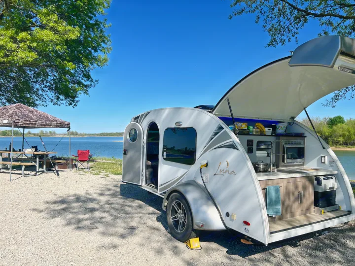 Cozy lakeside rv rental: a teardrop camper with an open outdoor kitchen, shaded picnic area, and clear blue sky views.. InTech RV InTech RV Trailer 2018
