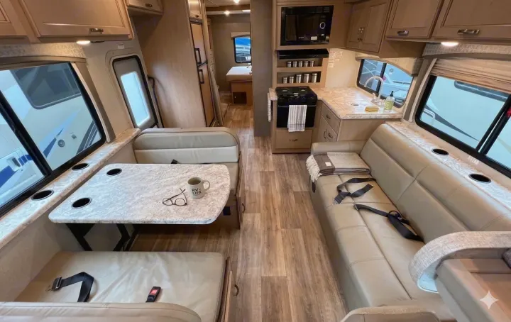 Spacious RV rental interior featuring a dinette, kitchen, and sofa for comfortable travel adventures.. Thor Motor Coach 30d 2020