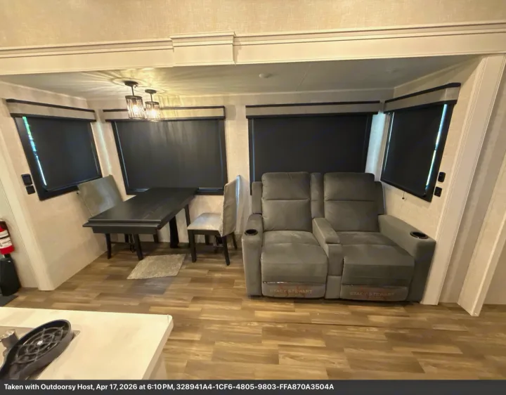 Spacious RV rental interior: dining table, comfy gray reclining sofa, and blackout window shades.. Jayco Eagle 2025