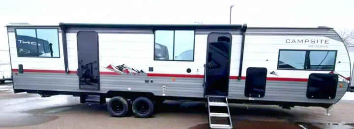 This modern gray and white 'Campsite Reserve' travel trailer, with dual doors, steps, and an awning, is ready for your next rv rental adventure.. Forest River Campsite Reserve 2026