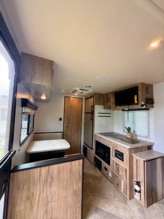 Modern RV rental interior featuring a well-appointed kitchen, dinette, and entertainment area. Ideal for travel comfort.. Forest River Palomino Real-Lite Mini 2021