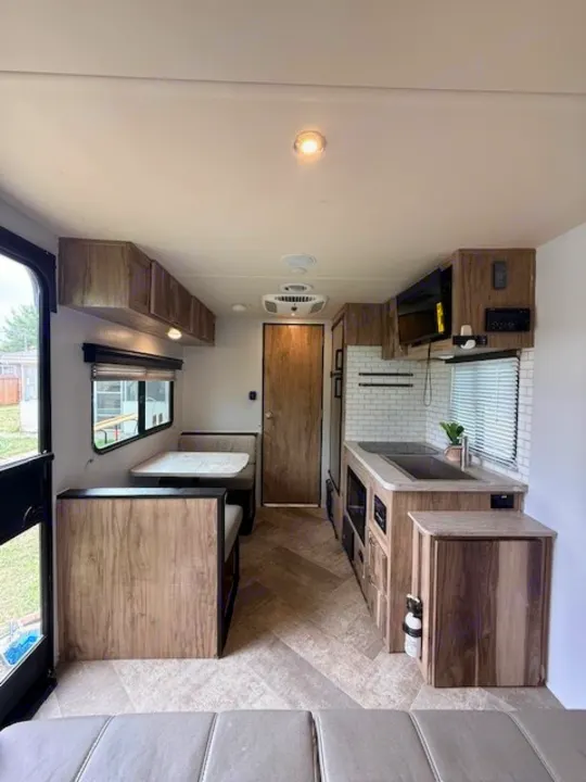Experience comfort in this modern rv rental. Features a cozy dinette, compact kitchen, and stylish wood interior.. Forest River Palomino Real-Lite Mini 2021