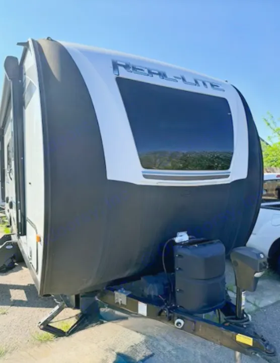 Front of a black and white Real-Lite travel trailer RV rental, featuring a large window, propane tanks, and a hitch for outdoor adventures.. Forest River Palomino Real-Lite Mini 2021