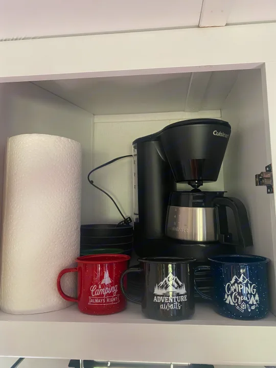 RV rental kitchen setup: Cuisinart coffee maker, paper towels, & various camping mugs for your adventures.. Keystone RV Hideout 2022
