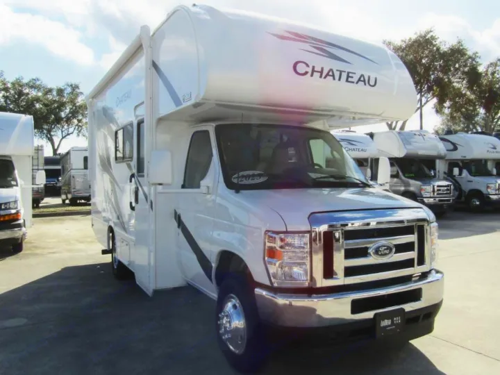 White Thor Chateau Class C RV rental, based on a Ford chassis, parked in a lot with other RVs.. Thor Chateau 2025