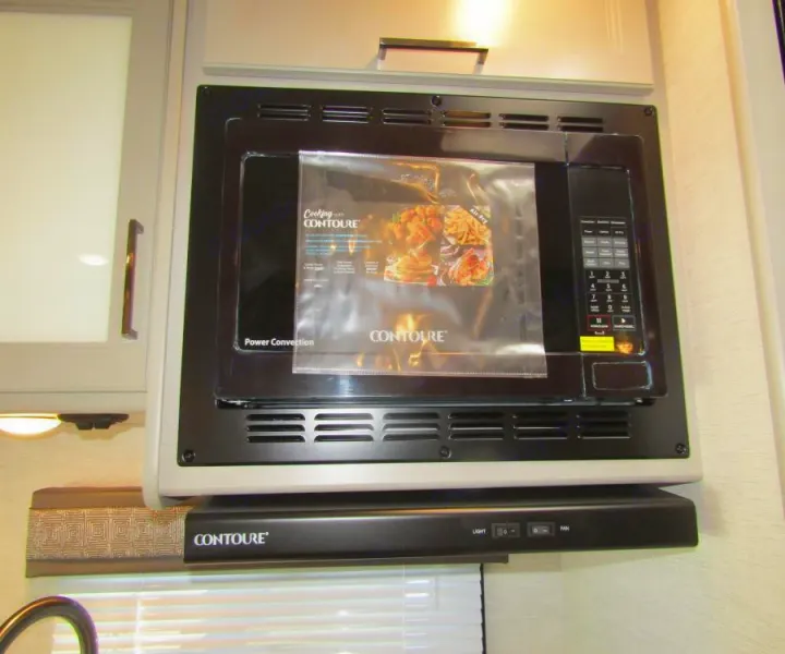 An RV rental kitchen showcasing a black Contoure convection microwave and matching range hood, ready for meal prep.. Thor Chateau 2025