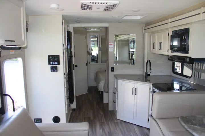 Spacious, modern rv rental interior with a full kitchen, comfortable dinette booth, and rear sleeping area.. Thor Motor Coach Ace 2024