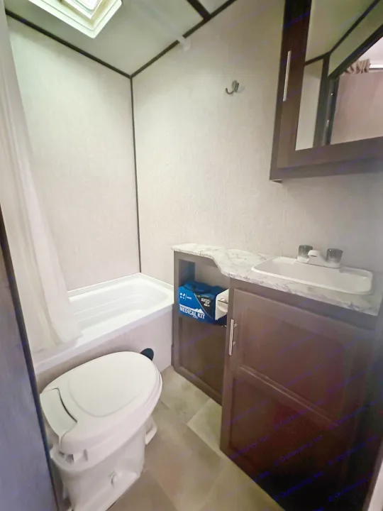 RV rental bathroom with toilet, tub/shower, vanity sink, storage, and mirrored cabinet for convenient travel.. Dutchmen Coleman Lantern 2020