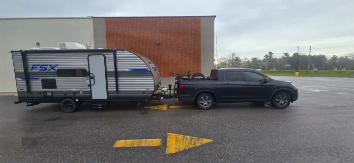 Black pickup truck towing a grey Salem FSX travel trailer with bikes, representing an RV rental setup.. Forest River Salem FSX 2020