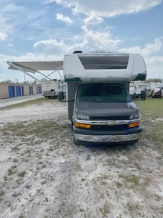 Class C RV rental with an extended awning, seen from the front, parked outdoors, ready for your next travel adventure.. Thor Quantum LC 2022