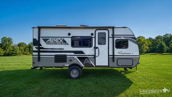 This compact Apex Nano off-grid travel trailer, ideal for your next RV rental adventure, rests on a lush green field.. Coachmen Apex Nano 2023