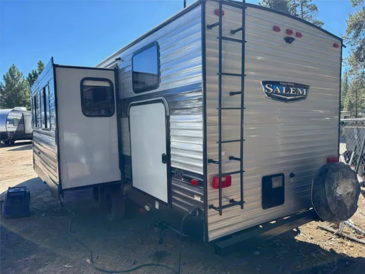 This Forest River Salem travel trailer, an RV rental, features a slide-out, rear ladder, and spare tire.. Forest River Salem 2022