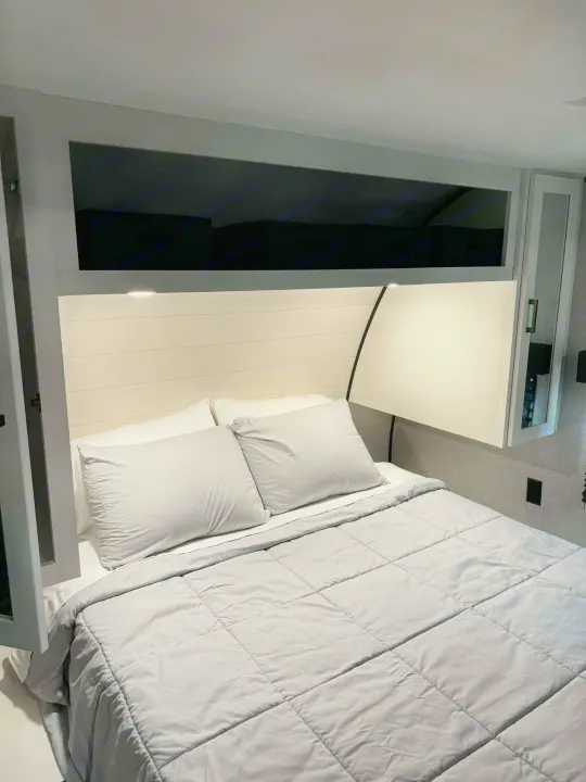 Cozy RV rental bedroom featuring a shiplap headboard, overhead storage, and a comfy bed with grey bedding.. Jayco Jay Flight SLX 2025