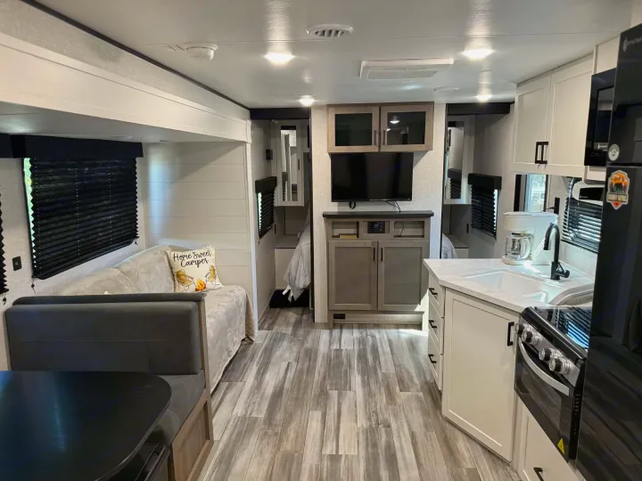 Inviting RV rental interior showcasing a modern kitchen, comfortable dinette, and cozy living space with a TV.. Jayco Jay Flight SLX 2025