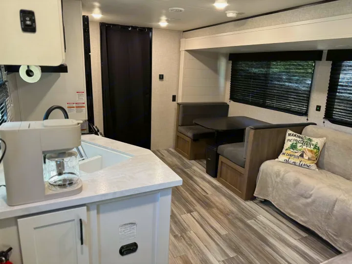 Modern RV rental interior: well-equipped kitchen, comfy dinette, and sofa area. Ready for your next road trip adventure.. Jayco Jay Flight SLX 2025
