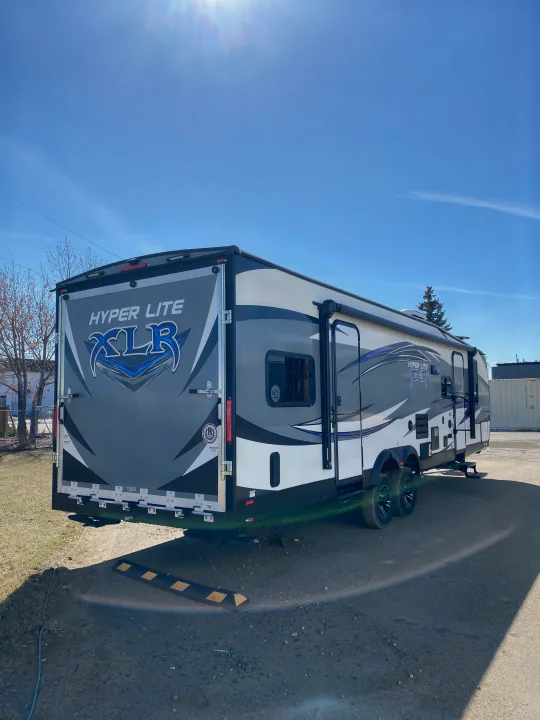 Discover this Hyper Lite XLR toy hauler travel trailer, an excellent rv rental. Parked outdoors on a clear, sunny day.. Forest River XLR HyperLite Toy Hauler 2017