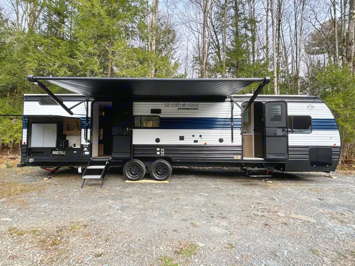 Spacious RV rental, a Cherokee Grey Wolf travel trailer with an outdoor kitchen, set in a peaceful wooded campsite.. Forest River Cherokee Grey Wolf 29TE 2026