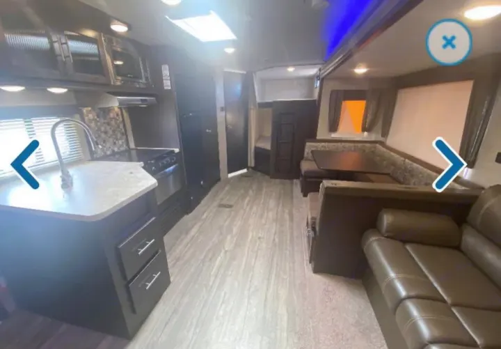 Spacious RV rental interior with modern kitchen, comfortable dining area, sofa, and bunk beds, ready for your next adventure.. Forest River Cherokee 2018