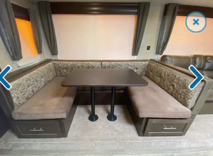 Comfortable U-shaped dinette with a dark table, plush seating, and storage drawers, perfect for your RV rental.. Forest River Cherokee 2018