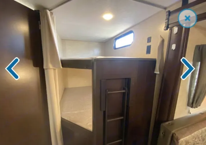 RV rental interior: Bunk beds with a ladder, window, and privacy curtains for a comfortable sleeping space.. Forest River Cherokee 2018