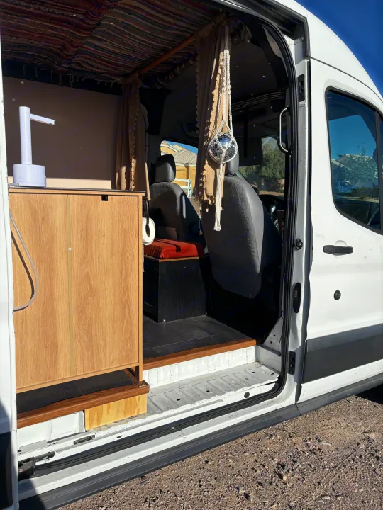 View inside an rv rental camper van: custom kitchenette, patterned ceiling, & a fun disco ball near the driver's seat.. Ford E350 Box Van 2015