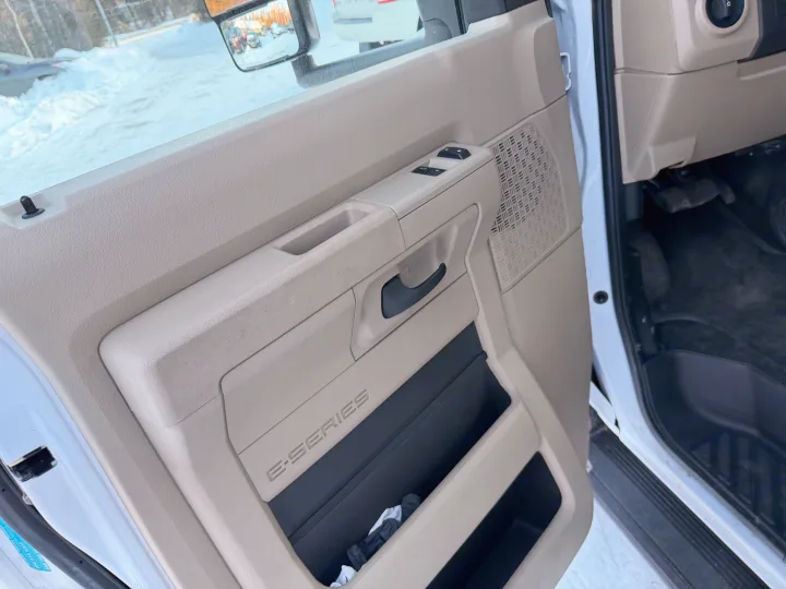 Interior of an RV rental van door with 'E-SERIES' branding, showing the window switch, door handle, and a snowy exterior view.. Forester Forester Motorhome 2020