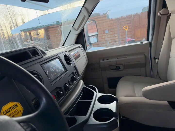 Inside an RV rental's cab, showing the dashboard, steering wheel, and passenger seat with a snowy view outside.. Forester Forester Motorhome 2020