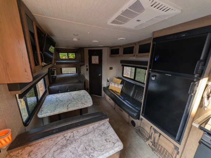 Spacious rv rental interior featuring a dinette, bunk beds, a comfy lounge, and Dometic fridge for your travels.. Grand Design Transcend 2020