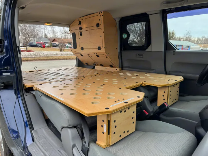 Explore this RV rental car's modular camp setup: a light wood bed platform with storage built into a vehicle conversion.. Honda Element 2010