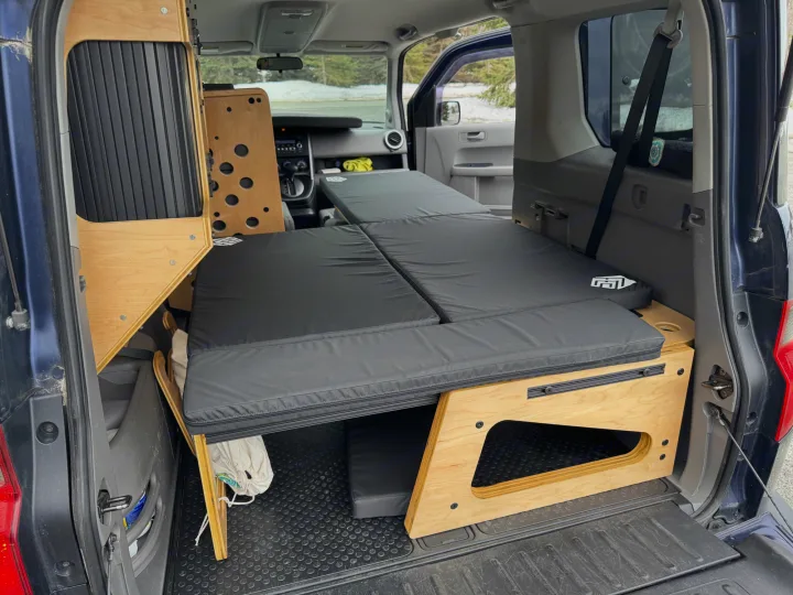 Inside a custom car camper setup: modular wooden sleeping platform & storage for adventurous rv rental trips.. Honda Element 2010