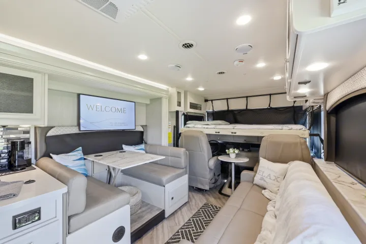 Spacious RV rental interior with modern dining, living, and bunk bed areas, ready for your adventure.. Fleetwood Fortis 2021