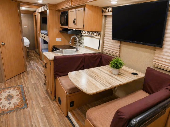 Inside an RV rental: full kitchen, dinette, mounted TV, and bunk beds. Compact living for your travels.. Thor Motor Coach ACE 2018
