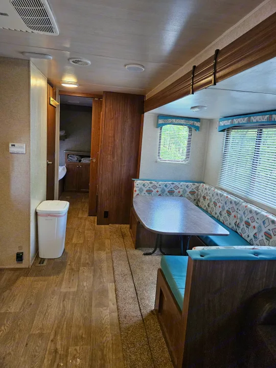 RV rental interior: U-shaped dinette, wood floor, and hallway leading to bunks. A comfy space for your adventure.. Heartland RVs Prowler 2018