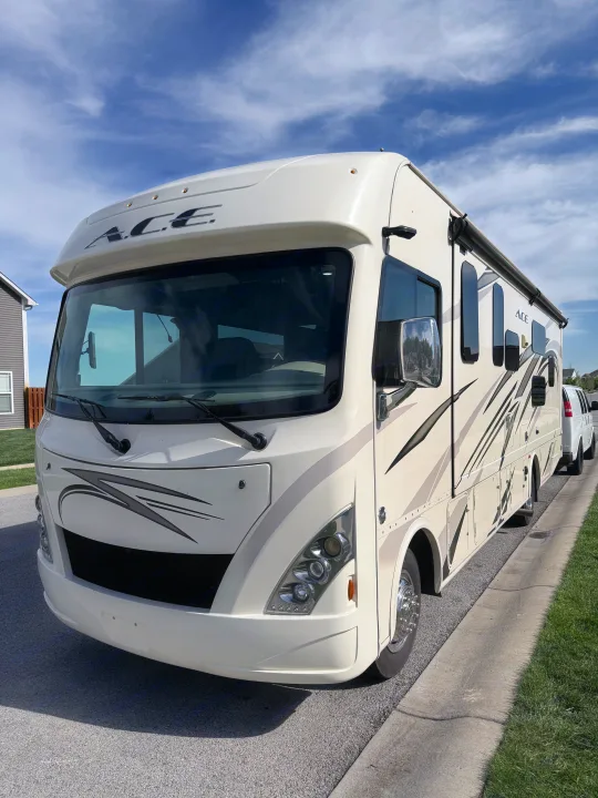 A large, white ACE RV rental motorhome parked on a sunny street, ready for your next travel adventure.. Thor A.C.E. 2018