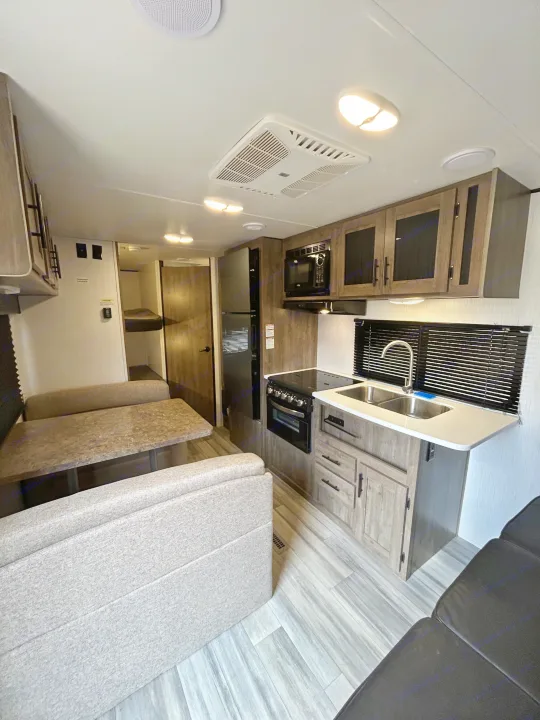 Modern RV rental interior with a fully equipped kitchen, dinette, and bunk beds for comfort.. Heartland RVs Pioneer 2022