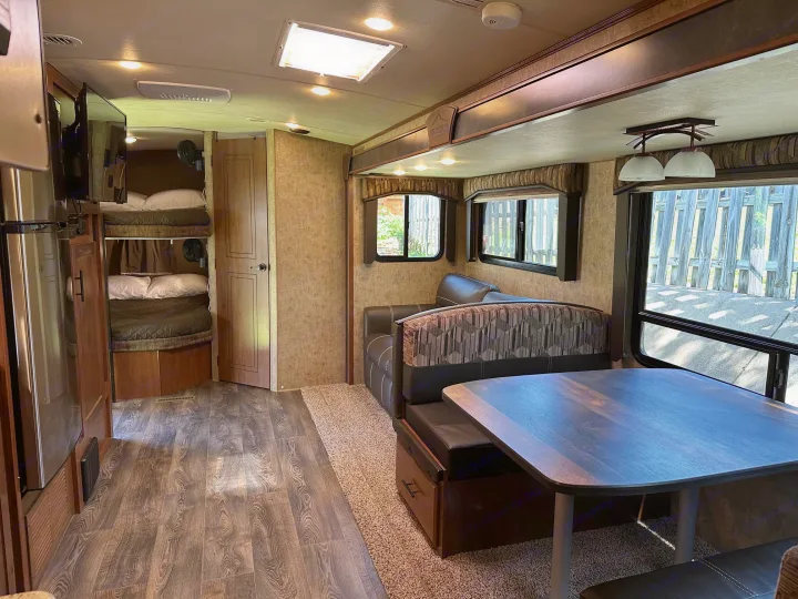 Comfortable RV rental interior featuring bunk beds, a dinette, and a cozy lounge area for family adventures.. Outdoors RV Timber Ridge 2020